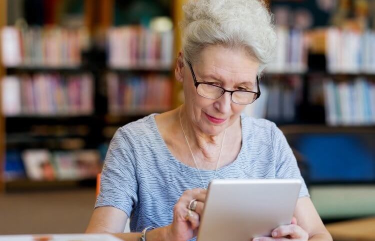 older adult looking at tablet