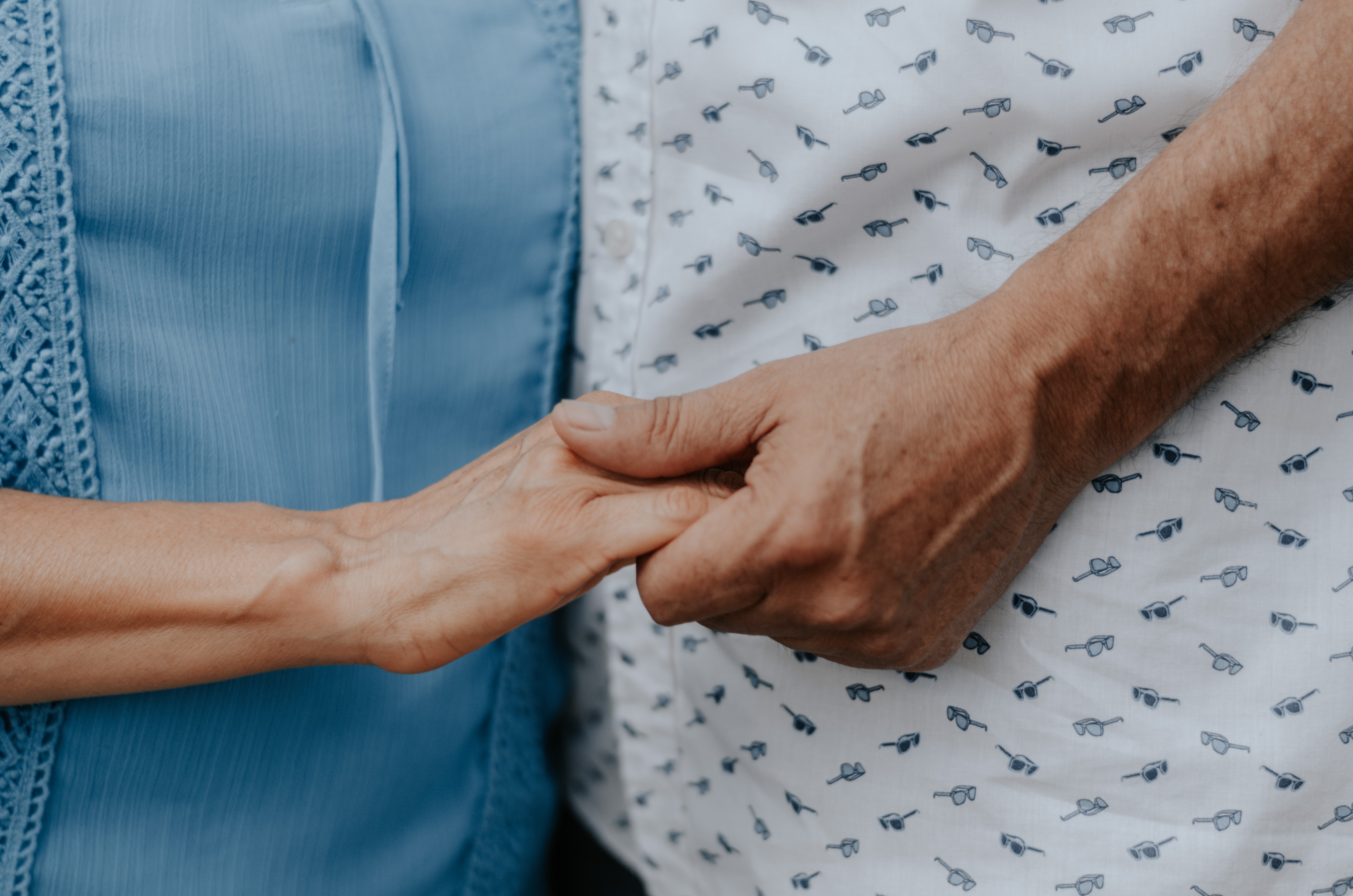 older adults holding hands