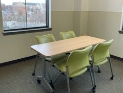 Study Room 1 - a rectangular table with four chairs in a room filled with sunlight