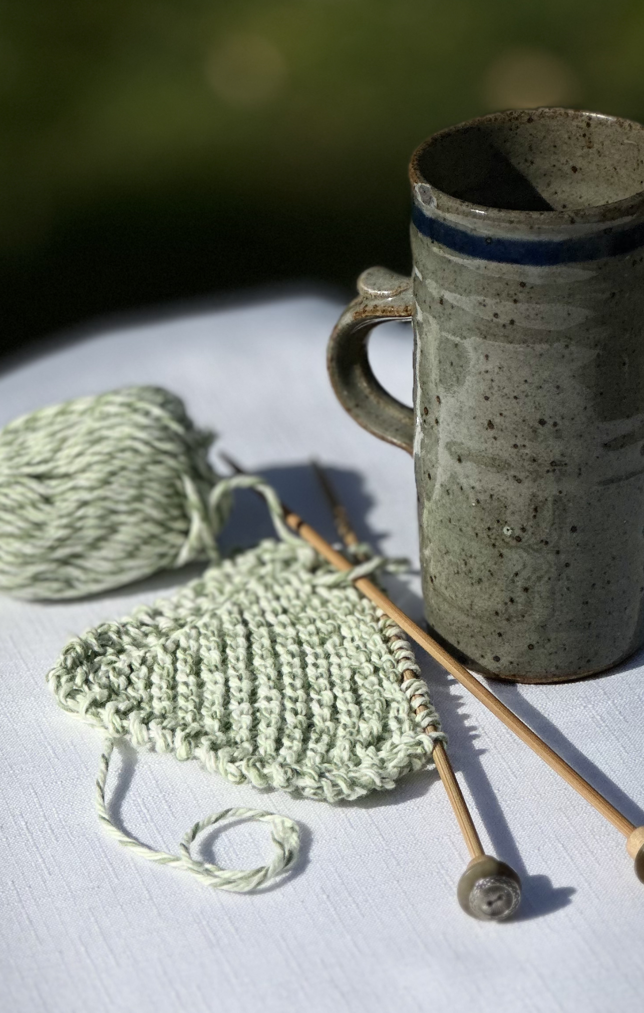 half knitted coaster and green mug