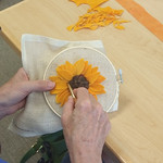 Program attendee creating a wool flower using rug hooking
