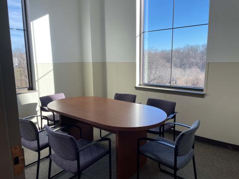 Study Room 2 - a oval table with six chairs in a sun filled room