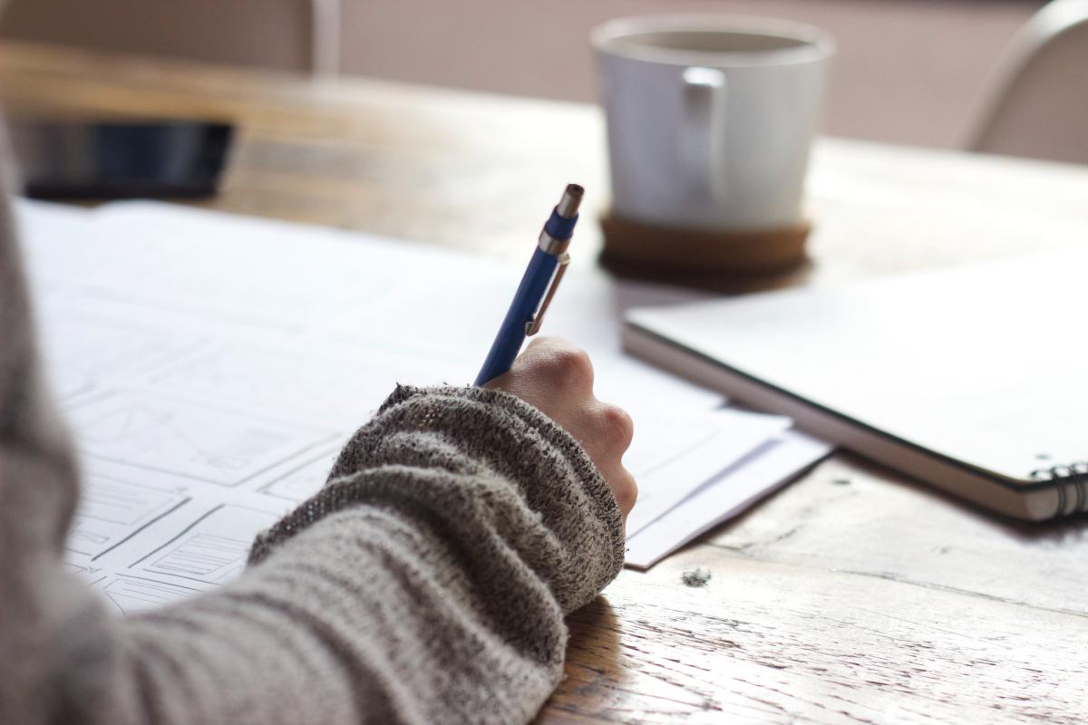 hand and arm of person writing at desk