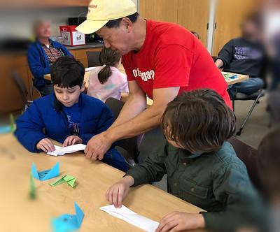 Origami artist demonstrating the art to program attendees