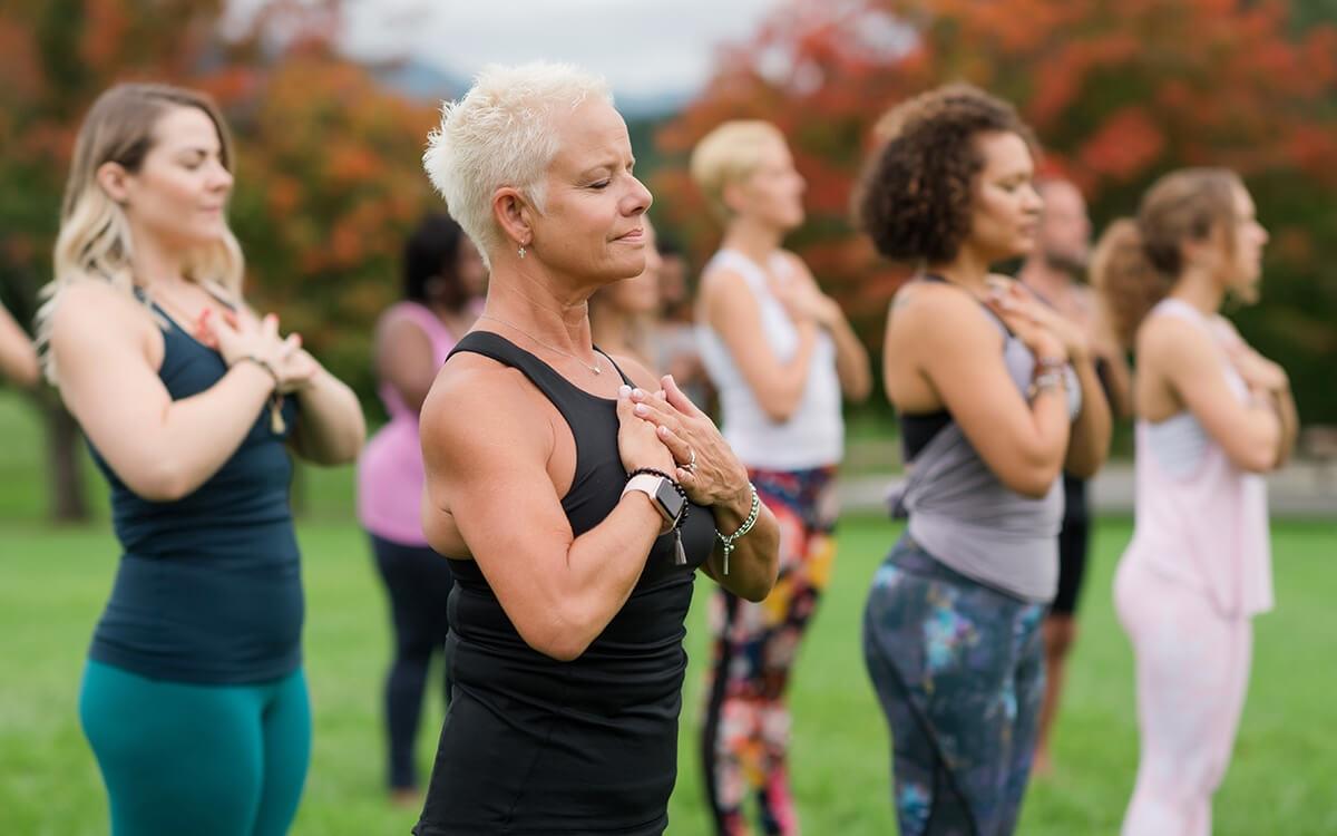 women standing outside with hands at heart